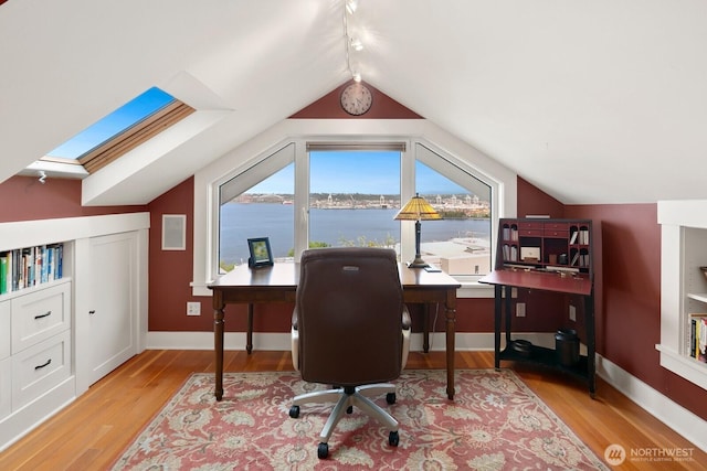 1712 Arch Ave SW, Seattle, WA 98116 - office area featuring wood finished floors, vaulted ceiling, a water view, baseboards, and a skylight