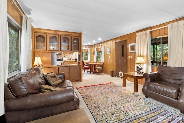 living area featuring light carpet and wooden walls