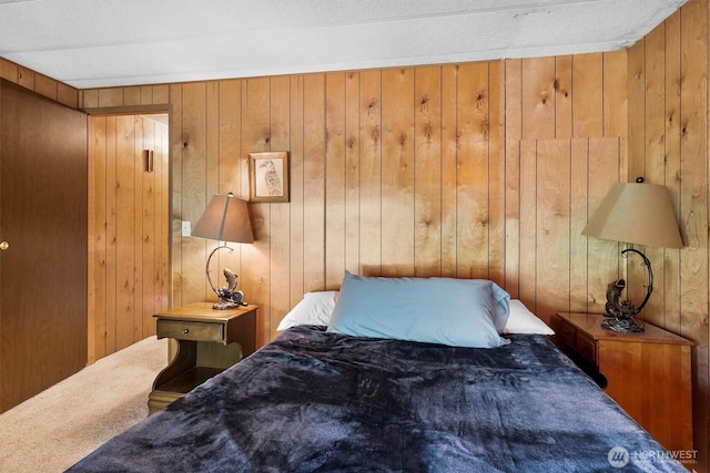 carpeted bedroom featuring wooden walls