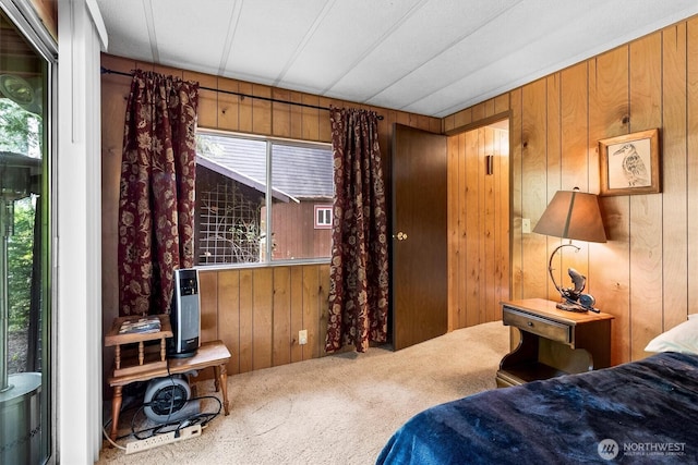 bedroom featuring carpet floors, wooden walls, and multiple windows