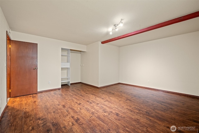 unfurnished bedroom with wood finished floors, baseboards, and a closet