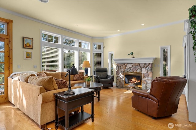 13901 Twin Lakes Dr E, Graham, WA 98338 - living room with a stone fireplace, light wood-style floors, healthy amount of natural light, and ornamental molding