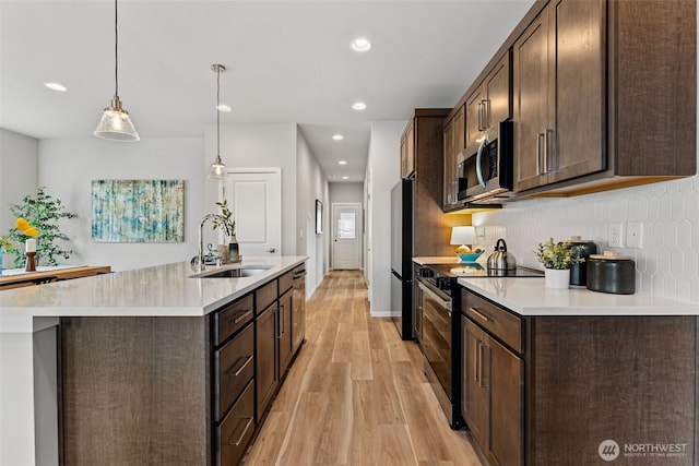 11 E Compass Ln, Allyn, WA 98524 - kitchen featuring appliances with stainless steel finishes, a sink, light wood-style floors, dark brown cabinets, and recessed lighting