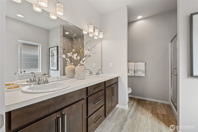 11 E Compass Ln, Allyn, WA 98524 - full bathroom with wood finished floors, toilet, double vanity, a shower stall, and baseboards