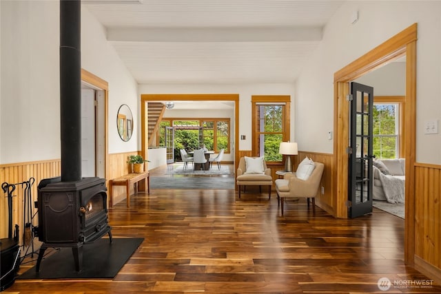 8285 NE Beck Rd, Bainbridge Island, WA 98110 - sitting room featuring wainscoting, a wood stove, wood finished floors, and wood walls