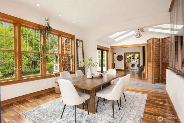 8285 NE Beck Rd, Bainbridge Island, WA 98110 - dining area with washer and clothes dryer, a skylight, wood finished floors, baseboards, and vaulted ceiling