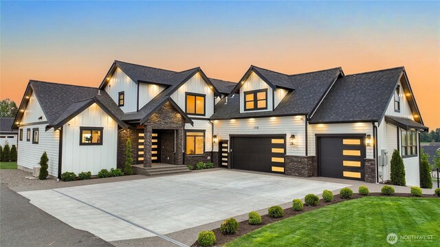 1750 Farmview Ter, Lynden, WA 98264 - view of front of house featuring stone siding, driveway, board and batten siding, a shingled roof, and a yard
