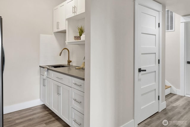 5754 W 26th Crst, Ferndale, WA 98248 - kitchen featuring a sink, decorative backsplash, light wood-style floors, and white cabinetry