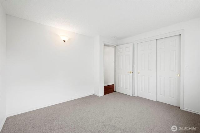 20302 52nd Ave W, Lynnwood, WA 98036 - unfurnished bedroom with carpet flooring, a closet, baseboards, and a textured ceiling