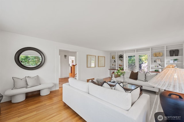 living room with light wood-type flooring and built in shelves