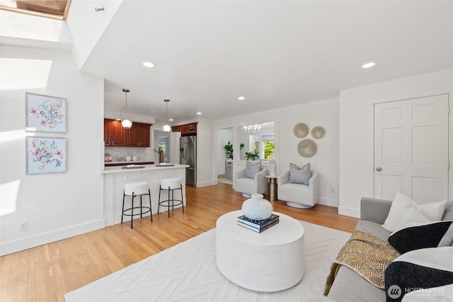 living room featuring recessed lighting, light wood finished floors, and baseboards