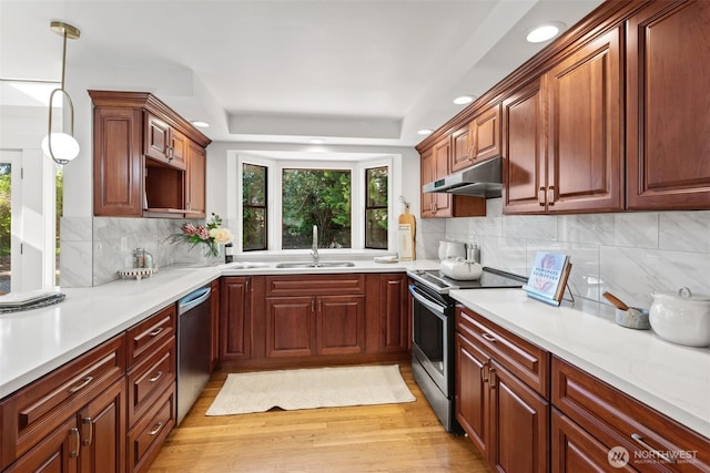 kitchen featuring appliances with stainless steel finishes, a sink, under cabinet range hood, recessed lighting, and light countertops
