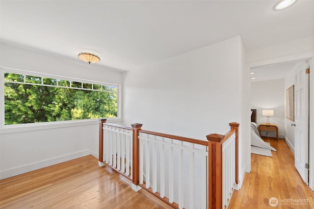 hallway featuring an upstairs landing, light wood-type flooring, baseboards, and recessed lighting
