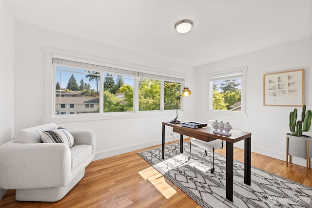 office space featuring baseboards and light wood-style flooring