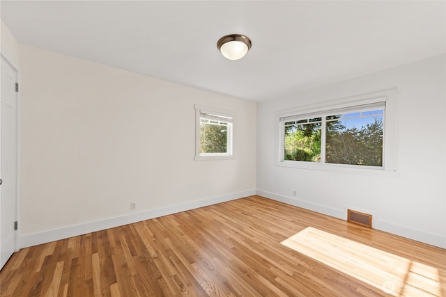 empty room featuring baseboards and light wood-style floors