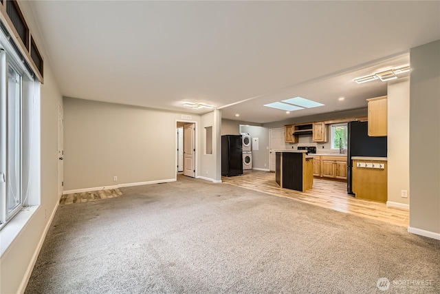 12814 NE 190th Pl, Bothell, WA 98011 - kitchen featuring stacked washer / drying machine, open floor plan, light colored carpet, baseboards, and a center island