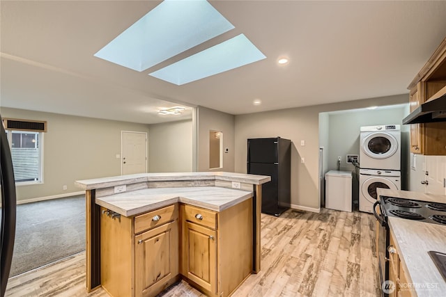 12814 NE 190th Pl, Bothell, WA 98011 - kitchen featuring black appliances, stacked washer / drying machine, a skylight, baseboards, and a kitchen island