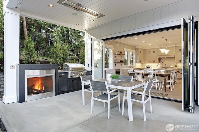 6950 SE Maker St, Mercer Island, WA 98040 - view of patio featuring grilling area, outdoor dining space, and exterior kitchen