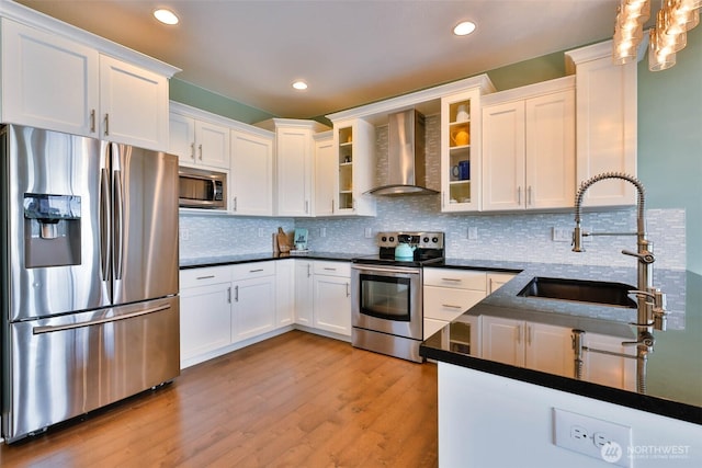 381 Lake Bay Loop SE, Ocean Shores, WA 98569 - kitchen with appliances with stainless steel finishes, wall chimney range hood, a sink, white cabinetry, and light wood-type flooring