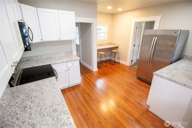 231 Karr Ave, Hoquiam, WA 98550 - kitchen with freestanding refrigerator, light wood-style floors, white cabinets, stove, and recessed lighting