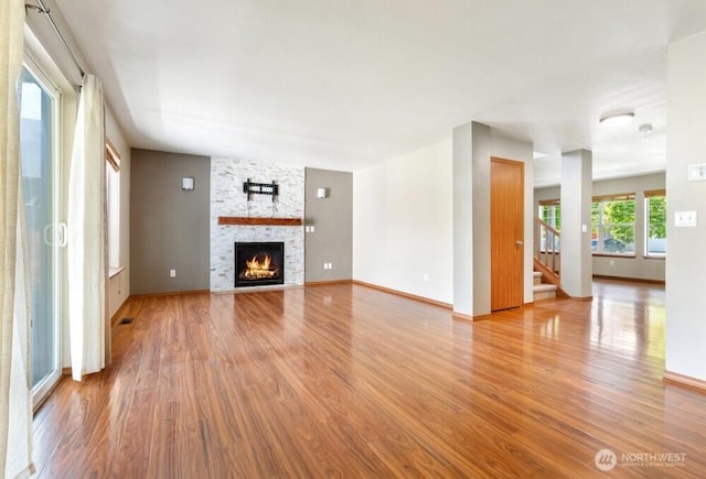 167 Wind River Rd, Chehalis, WA 98532 - unfurnished living room with light wood-style floors, stairway, a stone fireplace, and baseboards