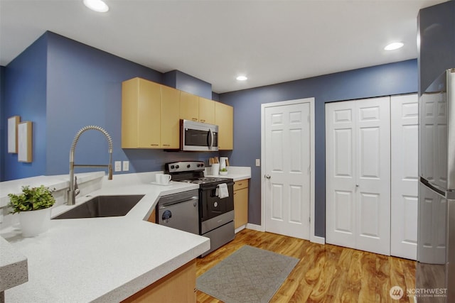 20802 72nd Ave W Unit 304, Edmonds, WA 98026 - kitchen featuring appliances with stainless steel finishes, a sink, light countertops, recessed lighting, and light wood-style flooring