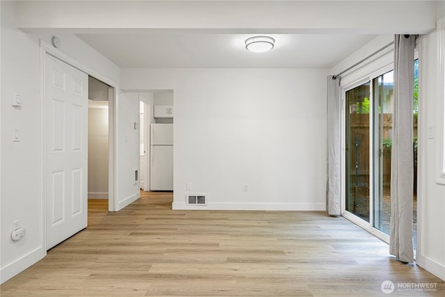 12211 SE 59th St Unit 61, Bellevue, WA 98006 - unfurnished bedroom with freestanding refrigerator, access to outside, light wood-type flooring, and baseboards