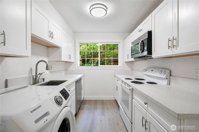 12211 SE 59th St Unit 61, Bellevue, WA 98006 - kitchen with stainless steel appliances, washer / clothes dryer, a sink, baseboards, and light wood finished floors