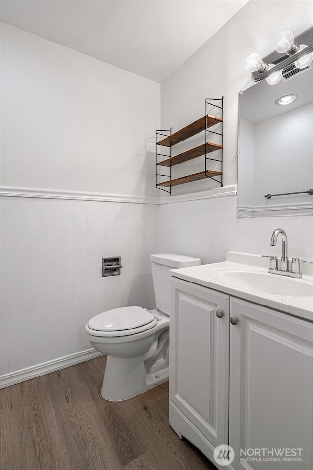 12211 SE 59th St Unit 61, Bellevue, WA 98006 - half bath with wood finished floors, toilet, vanity, and a wainscoted wall