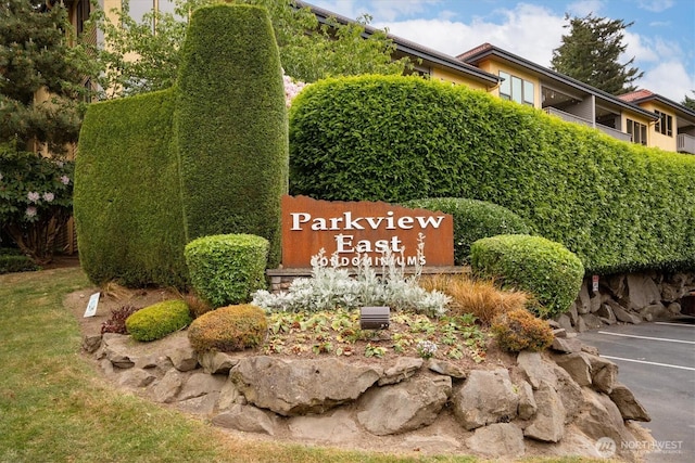 community / neighborhood sign featuring uncovered parking