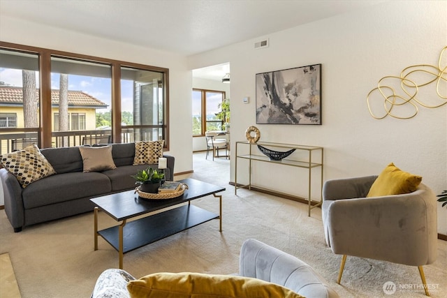 living room featuring light colored carpet and baseboards