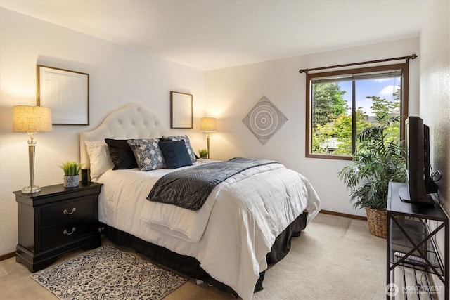 bedroom with light colored carpet and baseboards