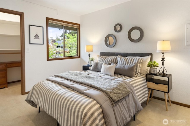 bedroom with light colored carpet and baseboards