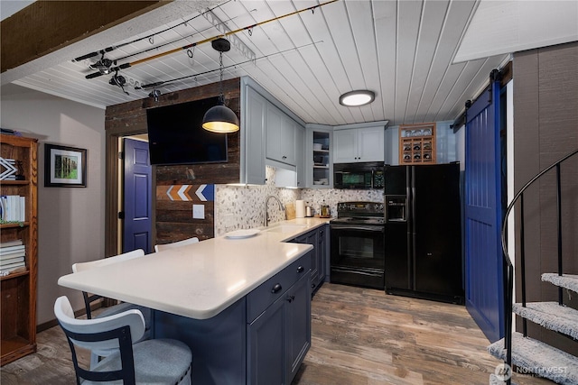 735 E Promontory Rd, Shelton, WA 98584 - kitchen featuring black appliances, a barn door, a sink, a peninsula, and light countertops