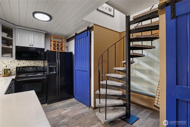735 E Promontory Rd, Shelton, WA 98584 - kitchen featuring a barn door, black appliances, light wood-type flooring, white cabinetry, and wooden ceiling