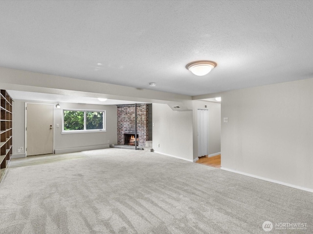 8711 Bowdoin Way, Edmonds, WA 98026 - unfurnished living room with light carpet, a fireplace, a textured ceiling, and baseboards