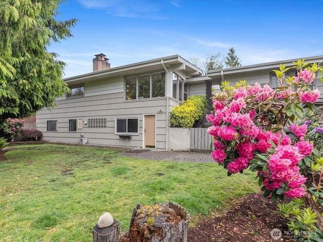 8711 Bowdoin Way, Edmonds, WA 98026 - rear view of property with a chimney and a lawn