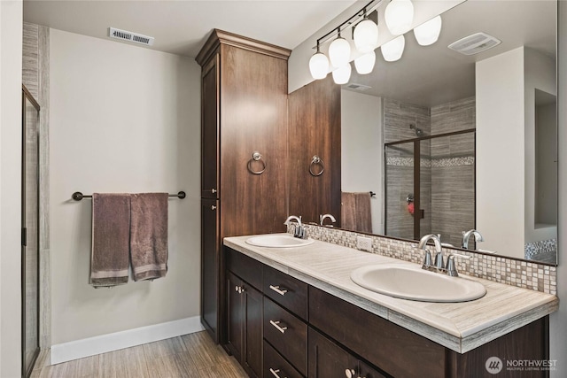 6410 83rd Avenue Ct W, University Place, WA 98467 - full bath featuring a stall shower, double vanity, baseboards, wood finished floors, and backsplash