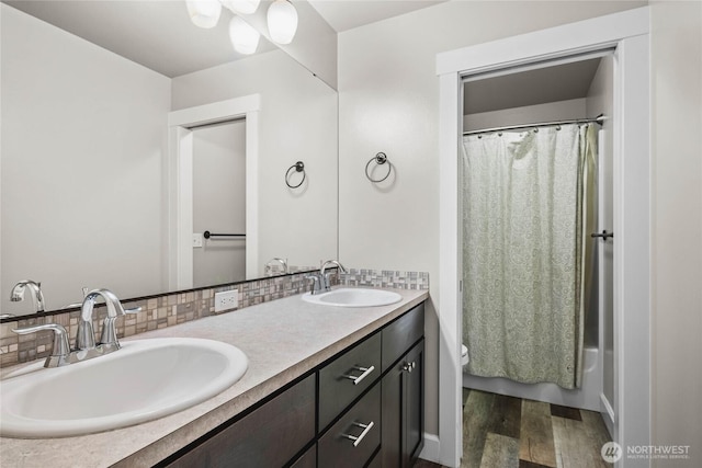 6410 83rd Avenue Ct W, University Place, WA 98467 - bathroom with double vanity, wood finished floors, toilet, and decorative backsplash