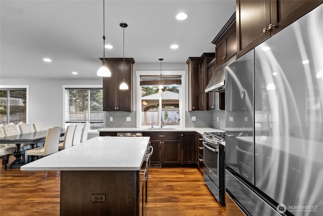 6410 83rd Avenue Ct W, University Place, WA 98467 - kitchen with stainless steel appliances, dark wood-style flooring, tasteful backsplash, dark brown cabinets, and a kitchen island