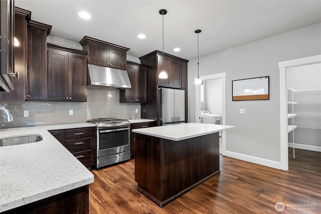 6410 83rd Avenue Ct W, University Place, WA 98467 - kitchen with stainless steel appliances, under cabinet range hood, a sink, independent washer and dryer, and dark wood-type flooring