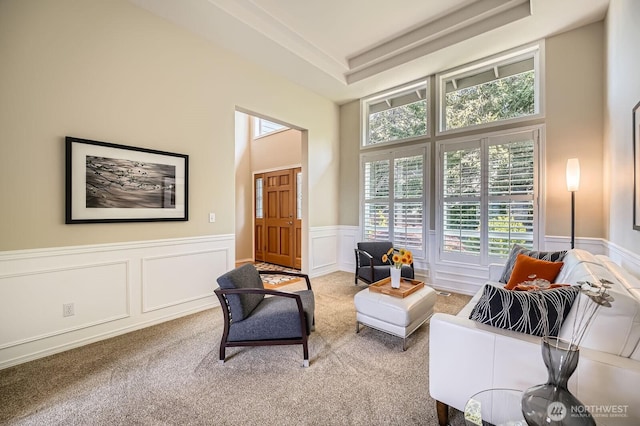 922 Chelan Ave NE, Renton, WA 98059 - living area with carpet floors, a high ceiling, wainscoting, a tray ceiling, and a decorative wall