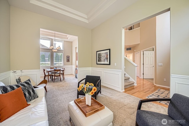922 Chelan Ave NE, Renton, WA 98059 - living room with a chandelier, stairs, a high ceiling, a wainscoted wall, and light carpet