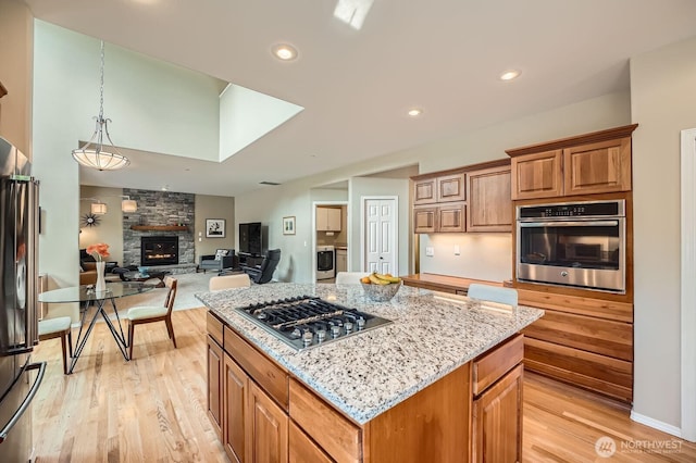 922 Chelan Ave NE, Renton, WA 98059 - kitchen with stainless steel appliances, light wood finished floors, light stone countertops, and recessed lighting