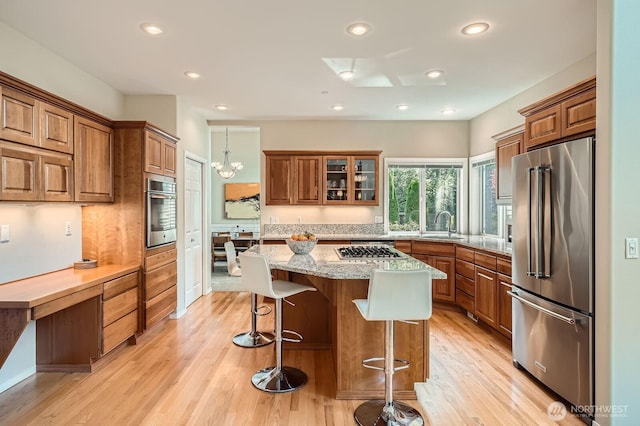 922 Chelan Ave NE, Renton, WA 98059 - kitchen featuring appliances with stainless steel finishes, brown cabinets, light wood-style floors, and recessed lighting
