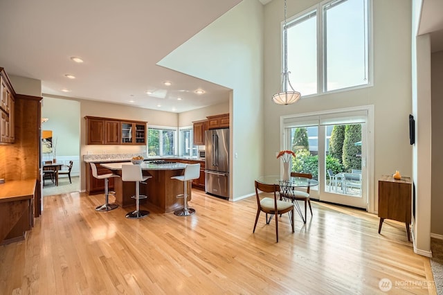 922 Chelan Ave NE, Renton, WA 98059 - kitchen with high end fridge, a kitchen island, a kitchen bar, light wood-style floors, and recessed lighting