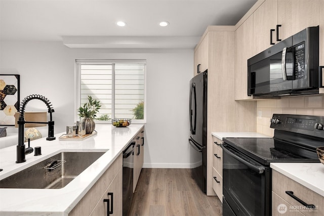 919 N 103rd St Unit A, Seattle, WA 98133 - kitchen with black appliances, a sink, light brown cabinets, wood finished floors, and recessed lighting