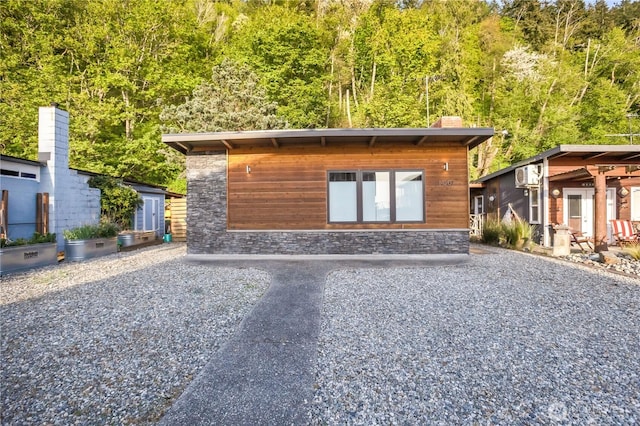 14207 Evergreen Way, Stanwood, WA 98292 - contemporary home featuring stone siding, a chimney, and a wall unit AC