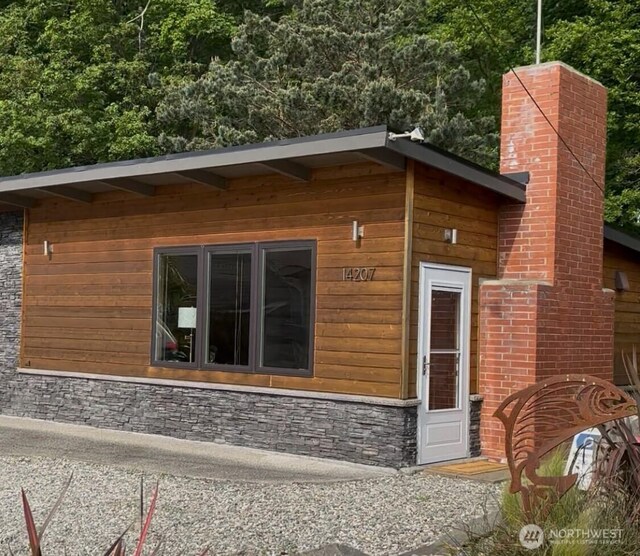 14207 Evergreen Way, Stanwood, WA 98292 - view of property exterior with a chimney and stone siding