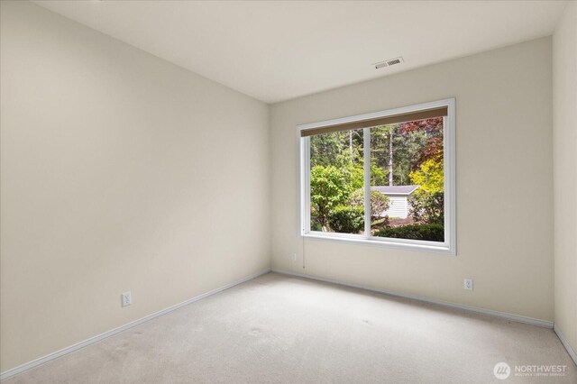 empty room with light colored carpet and baseboards